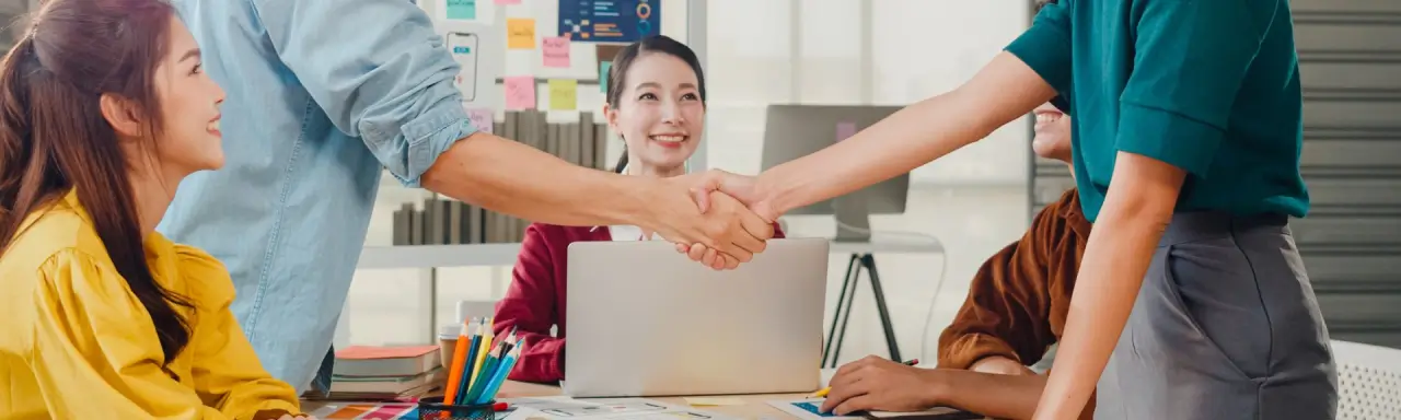 Two people shaking hands to represent link building collaboration and partnership